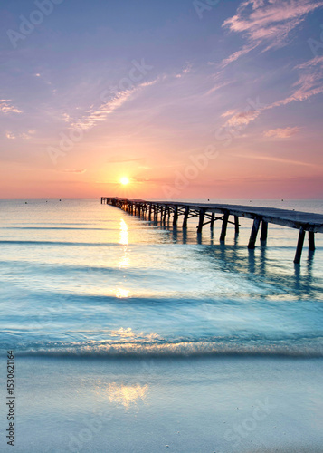 Endless Wooden Pier with wooden planks Stretching Over the Mediterranean Sea at a Vibrant Summer Sunrise