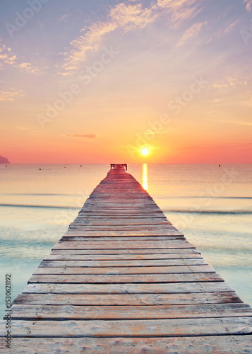 beautiful Wooden Pier Leading Over the Crystal Mediterranean Under a Radiant Summer Sunrise