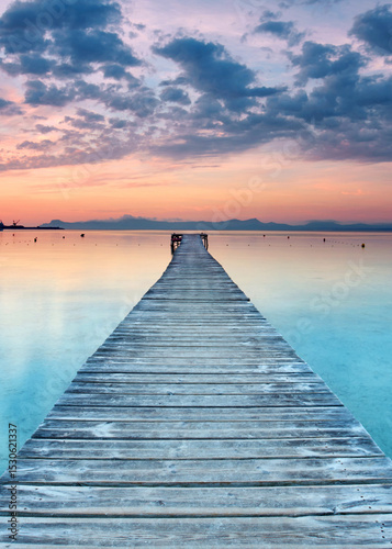 Serene Wooden Pier Vanishing Into the Golden Embrace of a Mediterranean Summer Sunrise