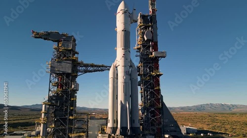 Powerful rocket on launchpad ready for space mission. Giant spaceship stands tall against clear blue sky. Impressive rocket poised for liftoff, a captivating image perfect for video production.