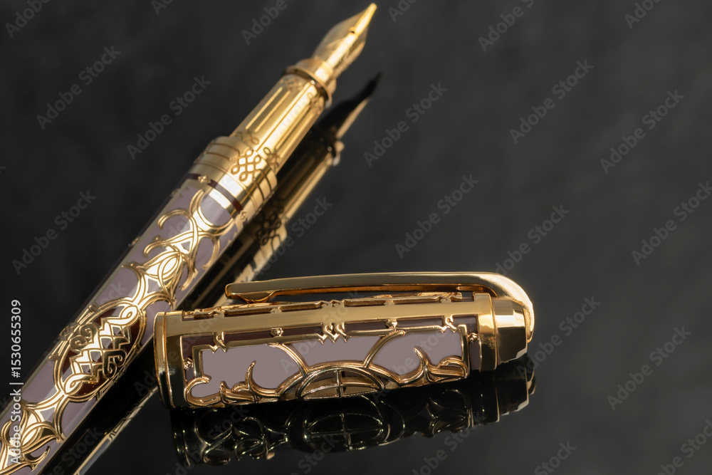Naklejka premium Fountain pen on gold color on marble gray background. Stationery.