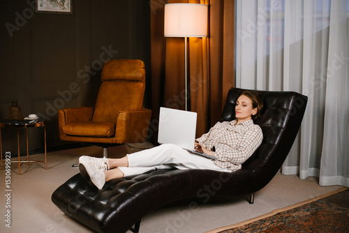 Woman Reclining In Therapist's Chair With Laptop