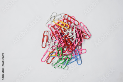 Pile of colorful paper clips on a white surface