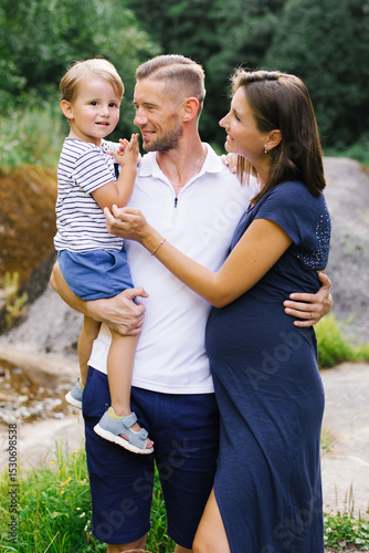 Happy Family Outdoors With Pregnant Mother And Little Son