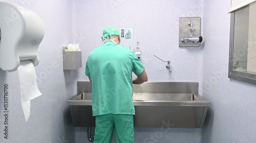 Surgeon scrubbing hands before surgery in OR