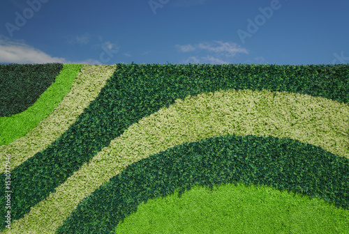 Plastic Plants Green Pattern on a Vertical Canvas with Bright Blue Sky. 