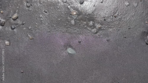 Gentle waves caress the black sand shore at twilight