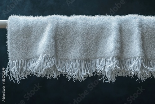 Hanging light gray throw blanket with white fringe