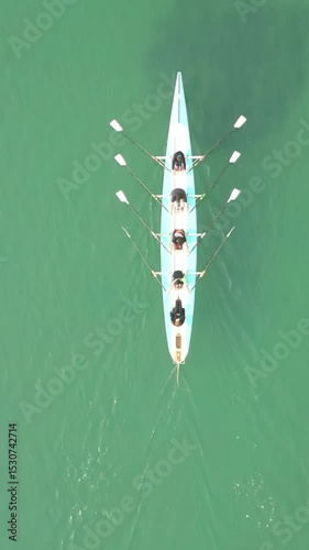 Sport Canoe with a team of four people rowing on tranquil water, Aerial view. High quality 4k footage