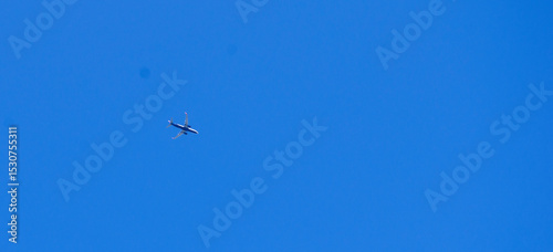 The passenger airplane is flying far away in blue sky.