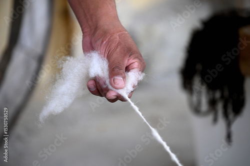 The weaver spun wool in his hand.