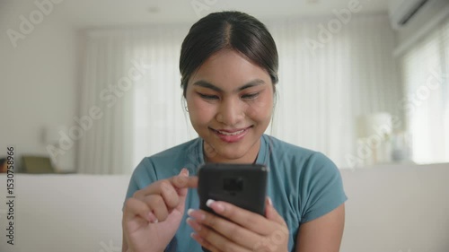 Young adult Gen Z people black asia woman sit at home sofa living room read look at mobile phone relax smile choose lover enjoy play choice right swipe app find love couple AI match flirt chat bot.
