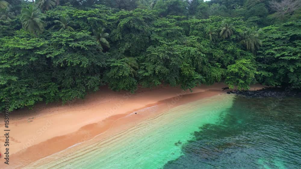Aerial backwards view from the transparant sea of Margarida beach with a boat anchored at se beach. Ilha do Principe (Prince Island),Africa