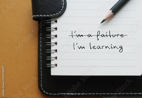 Notebook with text  I'M A FAILURE crossed off to  LEARNING, replace negative self-talk with positive thoughts, learn to build self-acceptance and embrace failure as part of growth and learning