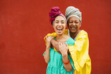 Happy african mother and daughter wearing traditional clothes - Travel, Africa, ethnic cultures and family concept - Focus on faces