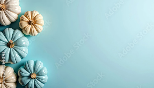 Blue and yellow pumpkins on pastel blue background, top view. Modern harvest and Halloween decor.