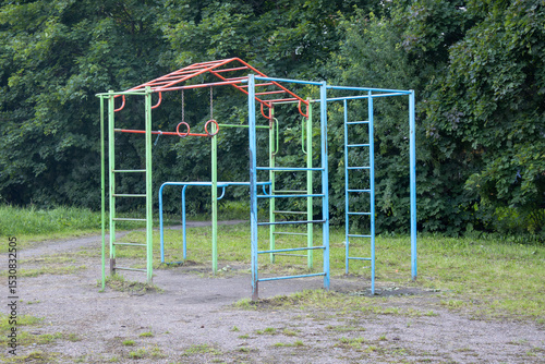 Colorful playground with a blue and green structure. The structure is made of metal and has a ladder