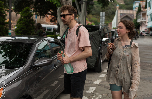 A couple explores the historic Abanotubani district in old town of Tbilisi on taxi and by foot enjoying panoramic views of rooftops and landmarks in summer afternoon