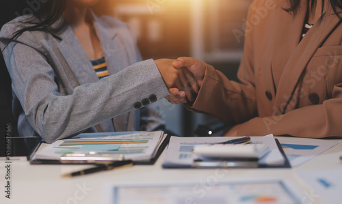 Man and woman are shaking hands in office. Collaborative teamwork.