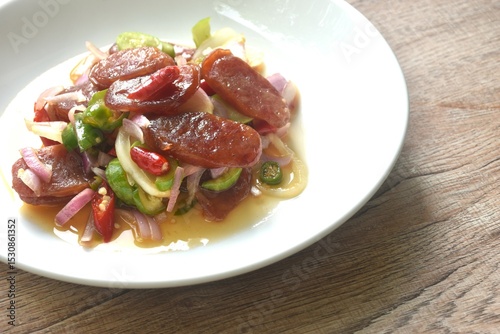 spicy and sour sweet slice Chinese pork sausage with vegetable salad on plate  