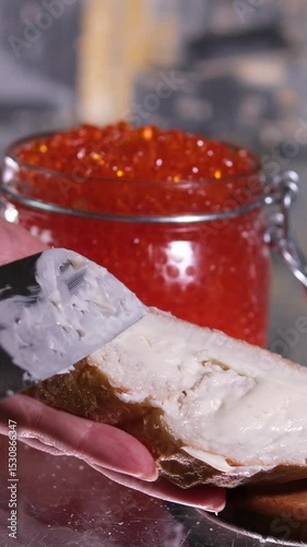 Man's hands takes a spoonful of red caviar and puts it on a piece of bread. Editing two frames. Close-up. . High quality 4k footage