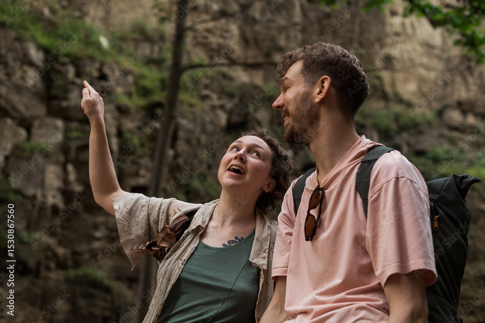 Naklejka premium A couple watches the Leghvtakhevi waterfall in the Tbilisi Old Town canyon in abanotubani, enjoying a peaceful moment surrounded by nature