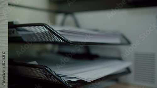 Hand placing documents in office paper tray