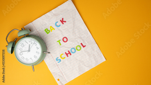 Time for back-to-school concept banner with clock and notebook paper on school bus yellow background