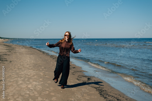 A girl runs by the sea in Latvia