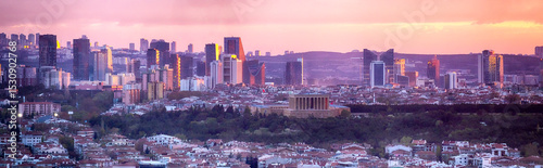 View of Anıtkabir and Ankara skyline at sunset with modern skyscrapers and a purple sky. The mausoleum of Atatürk stands out among the urban landscape of Turkey’s vibrant capital city.