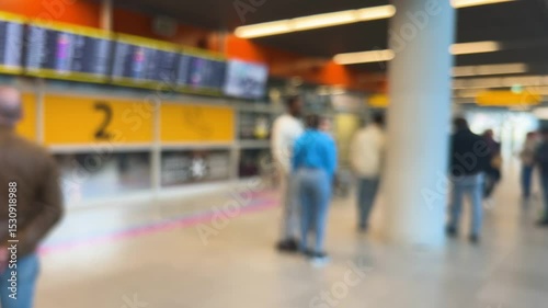 People waiting to greet passengers stand at arrival gate 2 at Warsaw Chopin Airport (WAW), Poland. Passengers arriving by plane exit with their luggage. Out of focus.