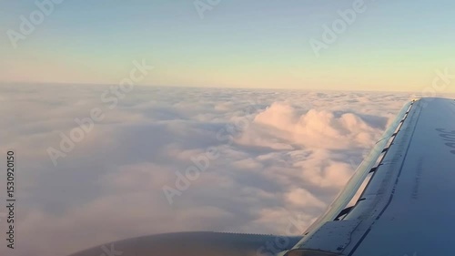 view from the airplane window onto the wing flying in the clouds