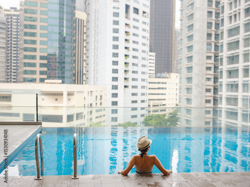 Canvas Print Young woman relaxing by the pool at a Kuala Lumpur hotel