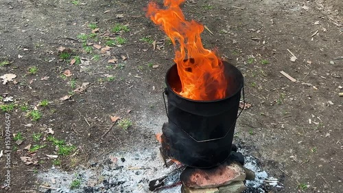Crude oil is melted in an iron barrel over a fire to treat wooden shingles from moisture.