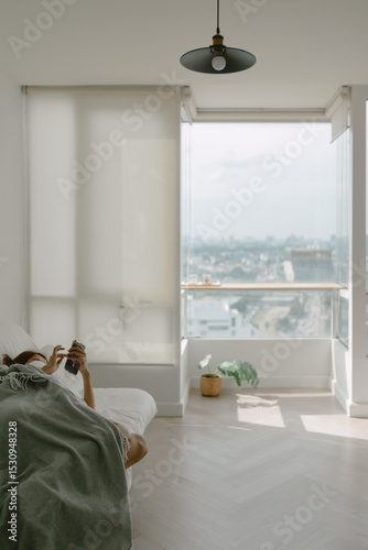 Woman taking a nap using phone in her apartment on weekends.