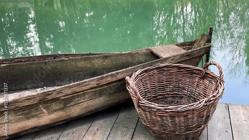 Antique wooden fishing boat and wicker fish baskets on the lake shore.