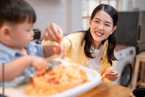Family member enjoys cooking and sharing a meal with a child in a warm kitchen setting during the day