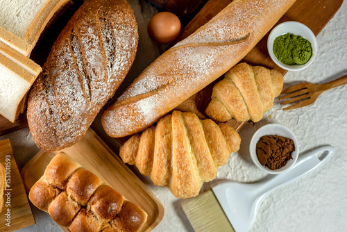 Mix bread kind of cereal bakery yeast white bread, pasties, buns, rye pretzel sourdough leavened tortilla and croissant on old wooden background.