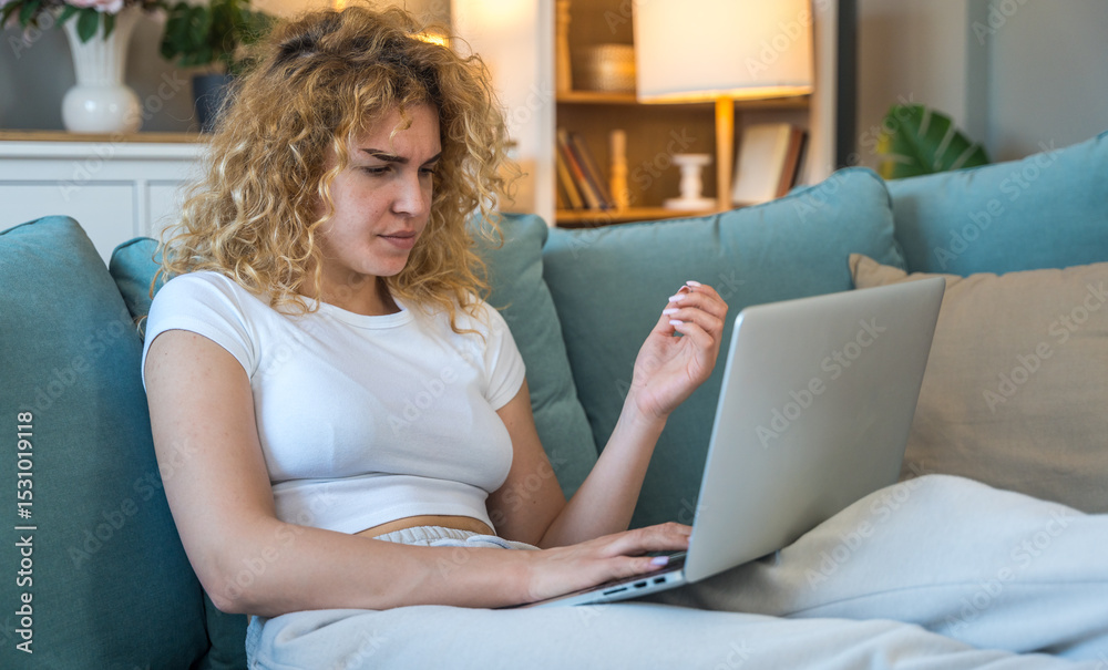 Young woman working from home on laptop experiencing technical issues such as internet disconnection, computer glitch or system error, frustrated and concerned while seated indoors Young woman working from home on laptop experiencing technical issues such as internet disconnection, computer glitch or system error, frustrated and concerned while seated indoors