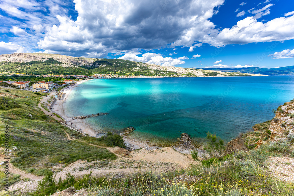 Obraz premium Hiking trail leading from the beach in Baska to the Bag mountain, city panorama seen from above,