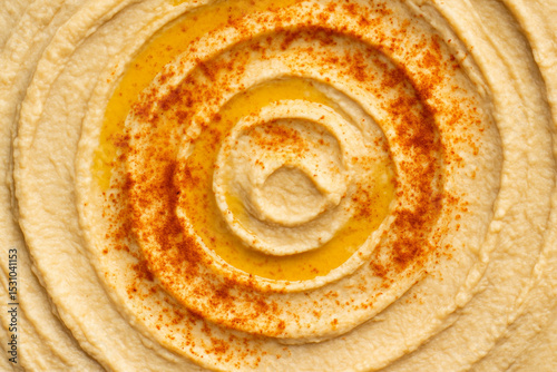 Creamy Hummus Swirl: A delectable close-up shot showcasing the smooth, creamy texture of hummus, artfully swirled with a sprinkle of paprika and a drizzle of olive oil.