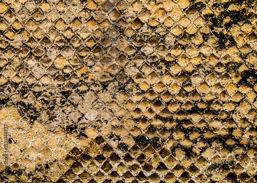Close-up of a textured, diamond-patterned surface with a weathered appearance.