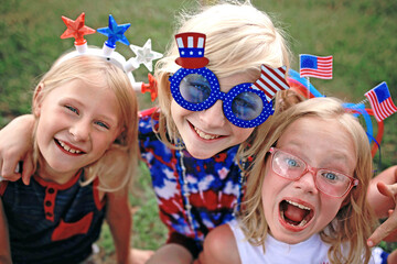 Happy and Smiling Patriotic Little Kids Sitting at a Fourth of July Parade in USA