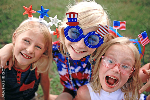 Happy and Smiling Patriotic Little Kids Sitting at a Fourth of July Parade in USA