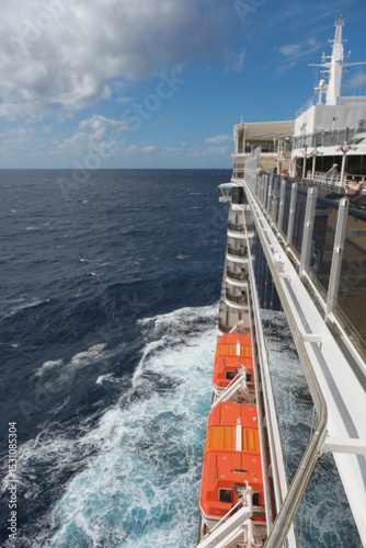 Outdoor promenade boat sun deck onboard modern luxury cruiseship cruise ship ocean liner with teak wood loungers and deck chairs for guests passengers