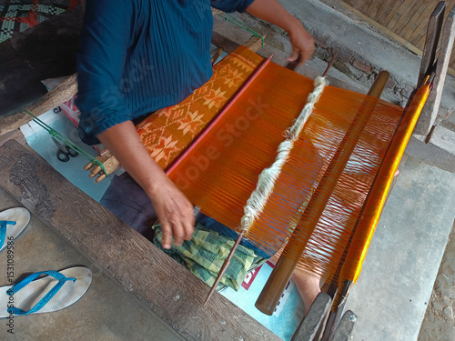 The process of making traditional handwoven fabric from Lombok, Indonesia, is done manually without using machines, employing tools made of wood.

 photo