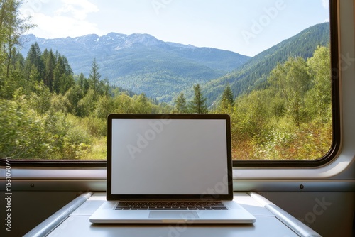 Laptop on train window, scenic view