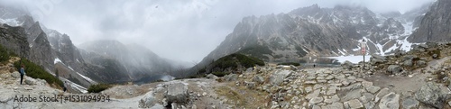 Panoramic Polish mountains landscape. Eye of the Sea lake. Foggy sky. Beautiful landscape from Carpathian Mountains in Poland. 