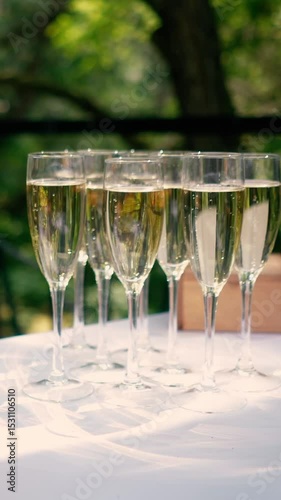 A glass of champagne stands on the festive table at the wedding of the bride and groom. Catering service on banquet food set on birthday, wedding celebration or business conference event venue