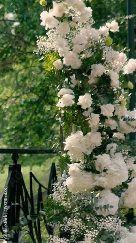wedding arch of white rose flowers on the river bank before the wedding ceremony of the bride and groom, festive romantic decor